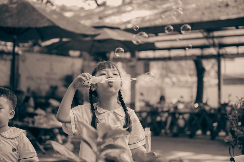 child blowing soap bubbles