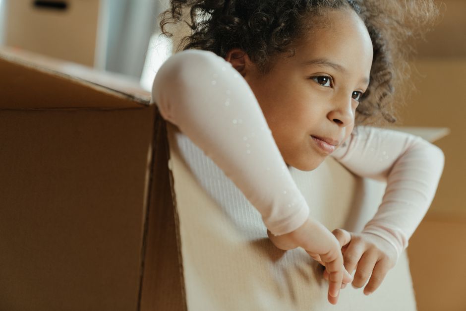 child playing with cardboard box