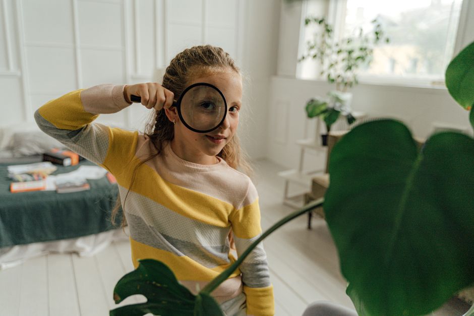child looking through magnifying glass